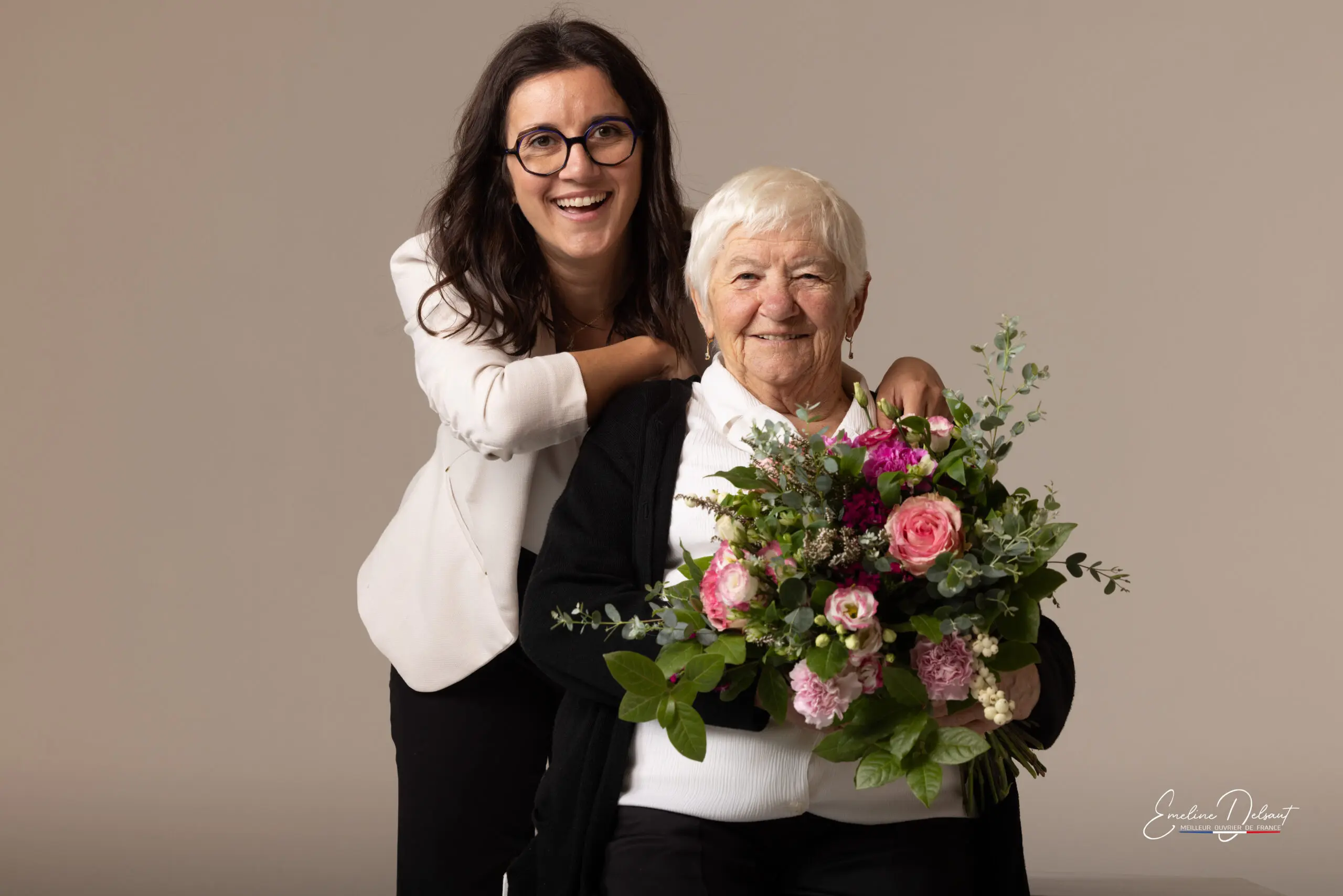 Une jeune femme pose avec sa grand mère qui tient un bouquet de fleur. Photo réalisée par Emeline Delsaut photographe professionnel